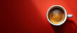A cup of espresso coffee on a red table seen from above.