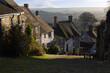 Gold Hill in Shaftesbury, Dorset, with attractive countryside backdrop