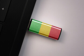 Wall Mural - usb flash drive in notebook computer with the national flag of mali on gray background.