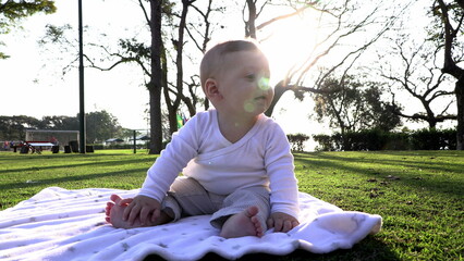 Canvas Print - Child baby seated at park during sunset