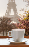 Fototapeta Miasta - Cup of coffee against famous Eiffel Tower during spring in Paris, France