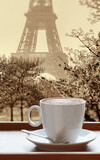 Fototapeta  - Cup of coffee against famous Eiffel Tower during spring in Paris, France