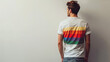 LGBTQ community concept, rear view of young man with pride movement LGBT Rainbow color t shirt logo against white background.