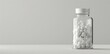 bottle of white pills on grey background with copy space