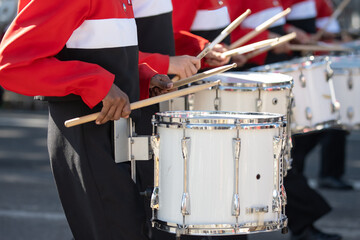 High school marching band drum line keeping rhythmn while participating in local parade