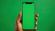 An African-American Woman uses her smart phone with her fingers that shows a green screen on the screen and background for creative to insert their products.
