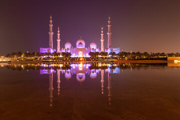 Wall Mural - Night view of Sheikh Zayed Grand Mosque in Abu Dhabi reflecting in a water, United Arab Emirates.