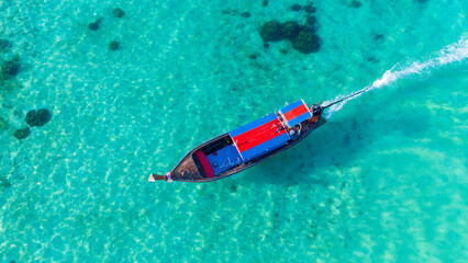 Traditional Thai longtail boat in the shallow waters of Phi Phi island, Krabi, Thailand. Boat tour in South East Asia concept.