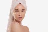 Fototapeta Zachód słońca - Calm serene young woman in spa bathrobe and towel relaxing after taking shower bath at home. Beauty treatment concept. Body skin and hair care