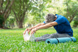 senior man with grey hair stretching his legs before doing yoga in the morning sunshine in park,concept prevent of injury, promote blood flow in elder people