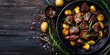 Meat stew and potato in cooking pot on dark rustic cutting board