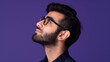 Profile view of young handsome Persian businessman with glasses looking up on purple color background professional photography