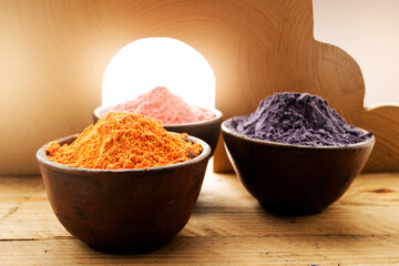 Wall Mural - Close up of holi powder in wooden bowl on art decoration background with sunlight.