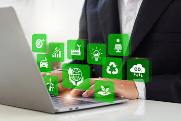 Wall Mural - Businessman analyze sustainability investment with icons of green business. Concept of Sustainable development. ESG, Co2, CSR, Green technology, Net zero, green energy and Carbon credit. Copy space.