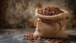 Rich brown roasted coffee beans spill from a burlap sack, their dark aroma promising a delicious and energizing cup of coffee