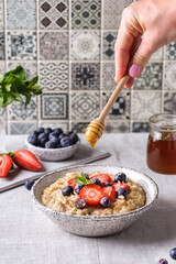 Wall Mural - oatmeal porridge with berries and honey