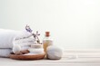 A bottle of essential oils and white towels on a wooden table. Ideal for spa and wellness concepts