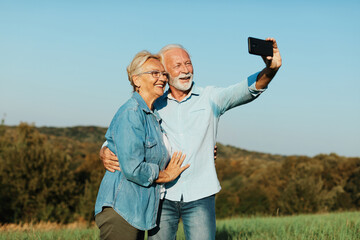 Wall Mural - woman man outdoor senior couple happy lifestyle retirement together smiling love selfie camera mature