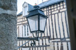 Metal lantern with a timbered house in the back - France Vannes