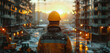 Man in construction helmet stands on the background of construction site at sunset