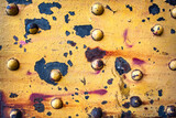 Fototapeta Miasto - Old Rusty Metal Surface with Bolts and Peeling Yellow Paint