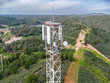 Aerial drone view of GSM, 4G, 5G and radio telecommunication towers on the top of a mountain. Cell phone tower and transceiver station. Antenna transmitter for wireless communication