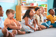 © Monkey Business - Line Of Smiling Primary Or Elementary School Students Sitting On Floor During Classroom Lesson