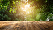 Wooden table with sunlit fresh green leaves, bokeh background. Copy space for product placement.
