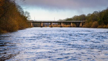 Poster - River Tyne upstream of Wylam Road Bridge.  The River Tyne at Wylam located in Northumberland on the tree-lined riverbanks of the Tyne Valley