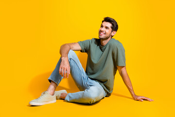 Poster - Full length photo of positive dreamy guy wear khaki t-shirt looking empty space isolated yellow color background