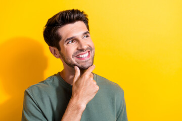 Poster - Portrait of optimistic guy with stubble wear stylish t-shirt fingers on chin look at promo empty space isolated on yellow color background