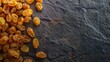 golden raisins on a dark stone background