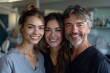 © Raptecstudio - A man and two women in formal wear smiling together at dental office