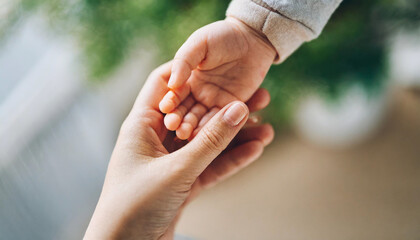 baby's hand grasping adult's hand, symbolizing trust and connection against clean background 