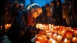 Face of a volunteer lighting a candle at a memorial ceremony