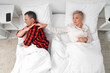 © Pixel-Shot - Offended mature couple lying after quarrel in bedroom