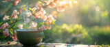Fototapeta  - photograph of a steaming cup of matcha tea set against a backdrop of a blossoming garden. with empty copy space