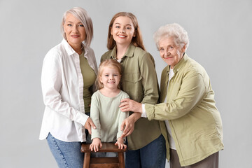 Wall Mural - Cute little girl with her family on light background