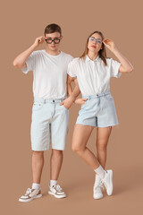 Wall Mural - Stylish young couple on brown background