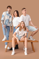 Poster - Group of stylish young people on brown background