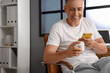 Middle-aged man checking pills description online at home