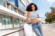 Photo of adorable pretty shiny girl dressed white crop top posing against modern architecture big city sunny spring outside
