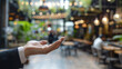 Businessman On An Open Palm. Blurred cafe background. Empty space where you can put your object or text