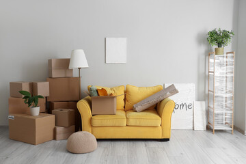 Canvas Print - Cardboard boxes and sofa in new living room on moving day