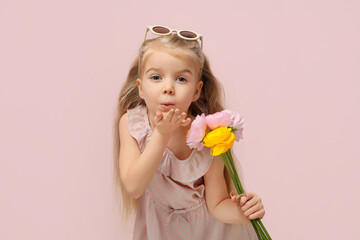 Sticker - Cute little girl with beautiful ranunculus flowers blowing kiss on pink background