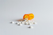 A close-up of white tablets spilled from a prescription bottle conveying health care and medication themes