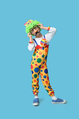 Poster - Cute little boy in clown costume with funny glasses on blue background. April Fools Day celebration