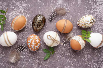 Wall Mural - Traditional decorated Easter eggs, feather and plants on grunge background