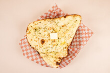 Indian Butter Naan Bread On Red Checker Paper In A Wooden Basket