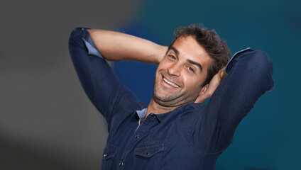 Poster - Portrait, relax or happy man in studio on a break for stretching or resting with pride or fashion. Calm model, face or confident male person with smile, freedom or wellness on grey or blue background